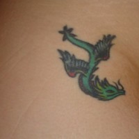 Tatuaje en la cadera, pequeño dragón que vuela