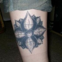 tatuaje en la pierna en tinta negra de la flor de loto
