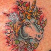 tatuaje de la cabeza de unicornio en flores