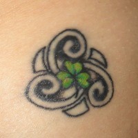 Tatuaje de un trébol con tres hojas dentro de una tracería