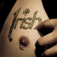 irish con quadrifoglio sul seno tatuaggio