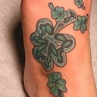 Tatuaje en el pie de unos tréboles verdes