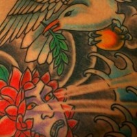 Tatuaje de un pajaro con la hoja en el pico y una cara mitologica