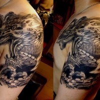 Tatuaje negro en el hombro de un dragón volando