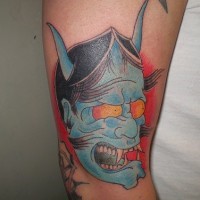 Blue japanese demon face tattoo