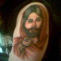 Tatuaje de Jesús que indica algo con el dedo indice