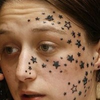 Tattoo von Sternchen auf dem Gesicht