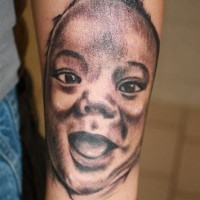 Smiling baby face tattoo