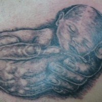 Little newborn in hands tattoo