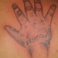 Baby hand with date of birth tattoo