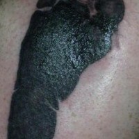 Baby footstep black ink tattoo