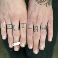Inscription hors de la loi tatouage sur les phalanges avec un petit brillant et le cœur