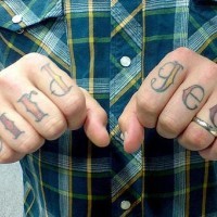 Tatuaggio a lettere grande sulle dita 
