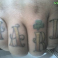 Knuckle tattoo, hard, styled with curls and clover inscription