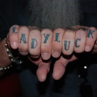 Knuckle tattoo, lady luck, blue styled inscription