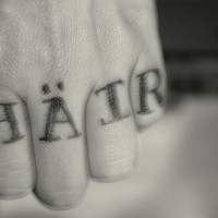 Tatuaje en los nudillos, escrito en otra idioma, hair