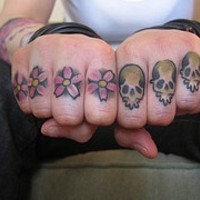 Tatuaggio sulle dita i fiori rosi e i teschi colorati