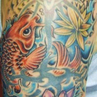 El tatuaje de un pez koi y una flor de loto hecho en color en el brazo o hombro