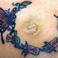 Le tatouage de mamelon avec un papillon sur les fleurs