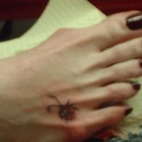 Kleineк Marienkäfer Tattoo am weiblichen Fuß
