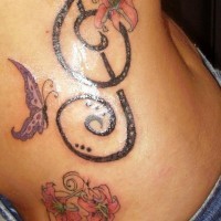 Tatuaje en la cadera, clave de sol grande, mariposa, flores