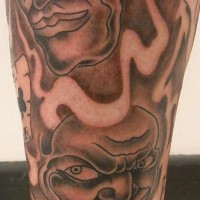Laughing clowns tattoo on leg