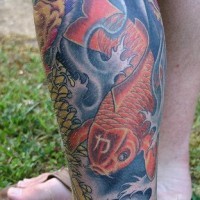 La carpa koi sul profondo del fiume tatuata sulla gamba