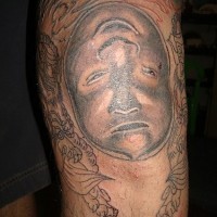 Visage étrange d'un homme horrible tatouage sur le mollet