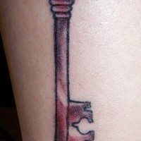 Bein Tattoo, langer, roter, verzierter Schlüssel