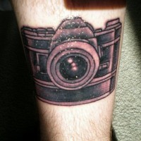 Grande camera fotografica tatuata sulla gamba