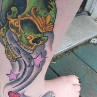 Leg tattoo, beautiful styled green skull with dimly breathe