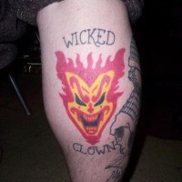 Tatuaje en la pierna, payaso malvado se ríe, en el fuego