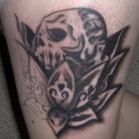 Leg tattoo, black skull inside of decorated flower