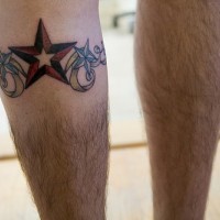 Tatuaje en la pierna, estrella volumétrico de colores rojo y negro, rizos
