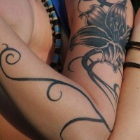 elegantissimo giglio nero sul tutto braccio tatuaggio
