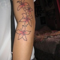 Minimalistic pink lilies tattoo on arm