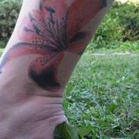 Orange and black lily tattoo on leg
