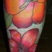 Tatuaje en la pierna de lirios color naranja y rosa