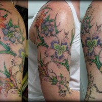 Le tatouage en couleur de branche avec des fleurs en floraison