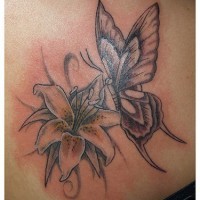 El tatuaje de un Lirio y una mariposa hecho con tinta negra