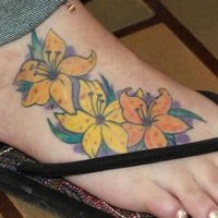 El tatuaje de unos Lirios amarillos hecho en un pie