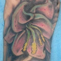 El tatuaje de un Lirio grande combinado con color negro hecho en un pie