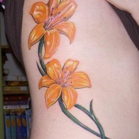 El tatuaje de dos Lirios de color naranja hecho en un costado