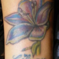 El tatuaje de una flor de Lirio con el nombre 