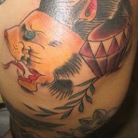 El tatuaje de la cabeza de un leon amarillo con ojos de color y un diamante