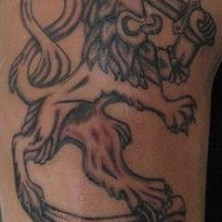 El tatuaje heraldico de un leon coronado con una corona y con una espada  en color negro