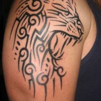 En tatuaje tribal de la cabeza de un leon rugiendo en el brazo o hombro