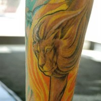 El tatuaje de un leon en el fuego hecho en color