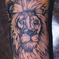 El tatuaje de la cabeza de un leon con ojos de color y el sol