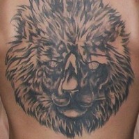 El tatuaje grande de la cabeza de un leon en color negro en la espalda